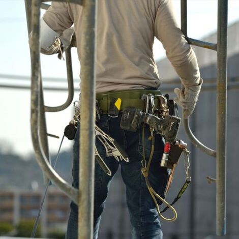 建枠を担ぐ職人